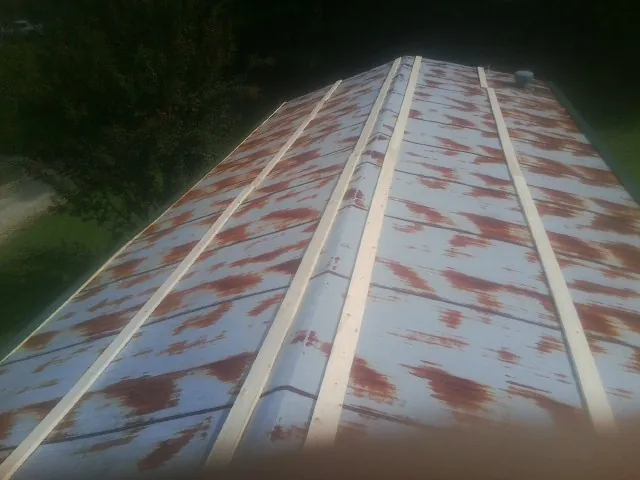 Rusted metal roof panels with new wood purlins before replacement — Storm Damage Roof Repair in Heflin by Roofing Brothers
