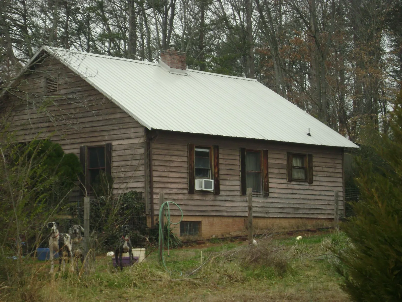 White metal roof on an old wood sided farmhouse, from a Asphalt Shingle Roof Repair job in Heflin